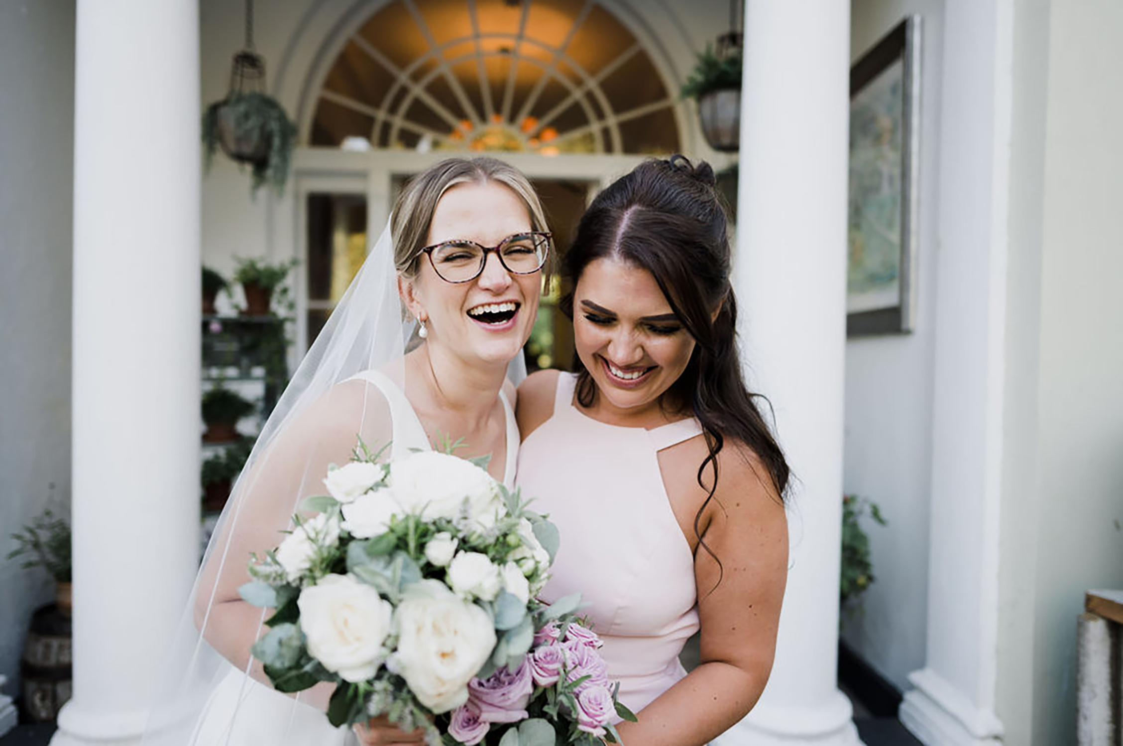 Liberty Pearl Photo & Film Collective Devon Wedding Photography at Deer Park Country House. Bride and bridesmaid holding flowers.