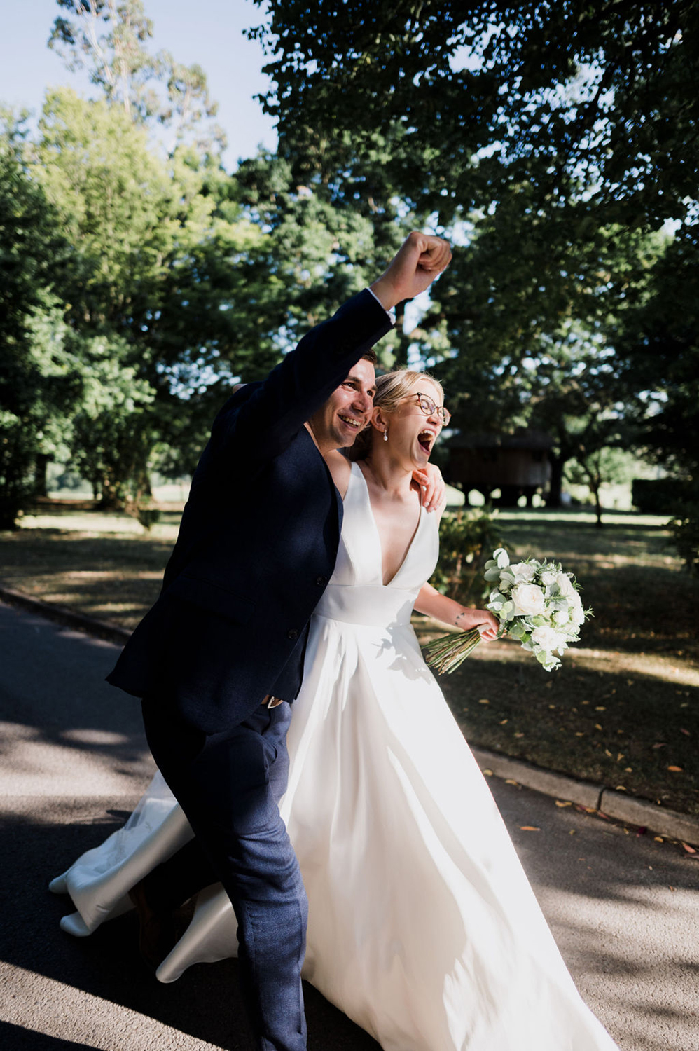 Liberty Pearl Photo & Film Collective Devon Wedding Photography at Deer Park Country House. Bride and groom celebrate holding flowers. 