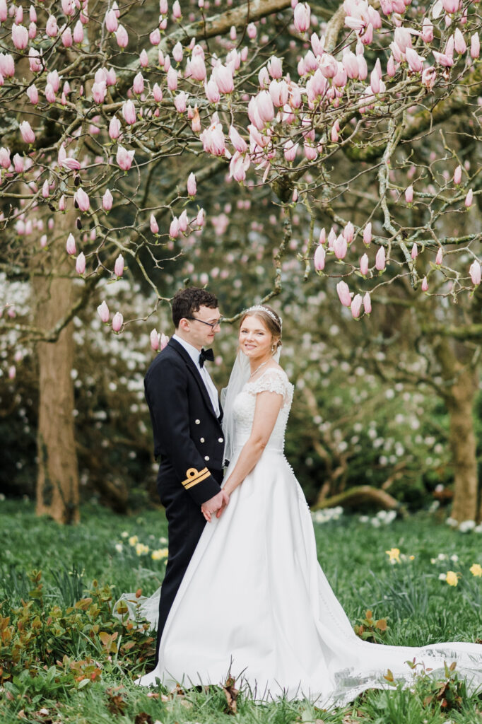 A newlywed couple standing in the gardens of Roswarne in Cornwall