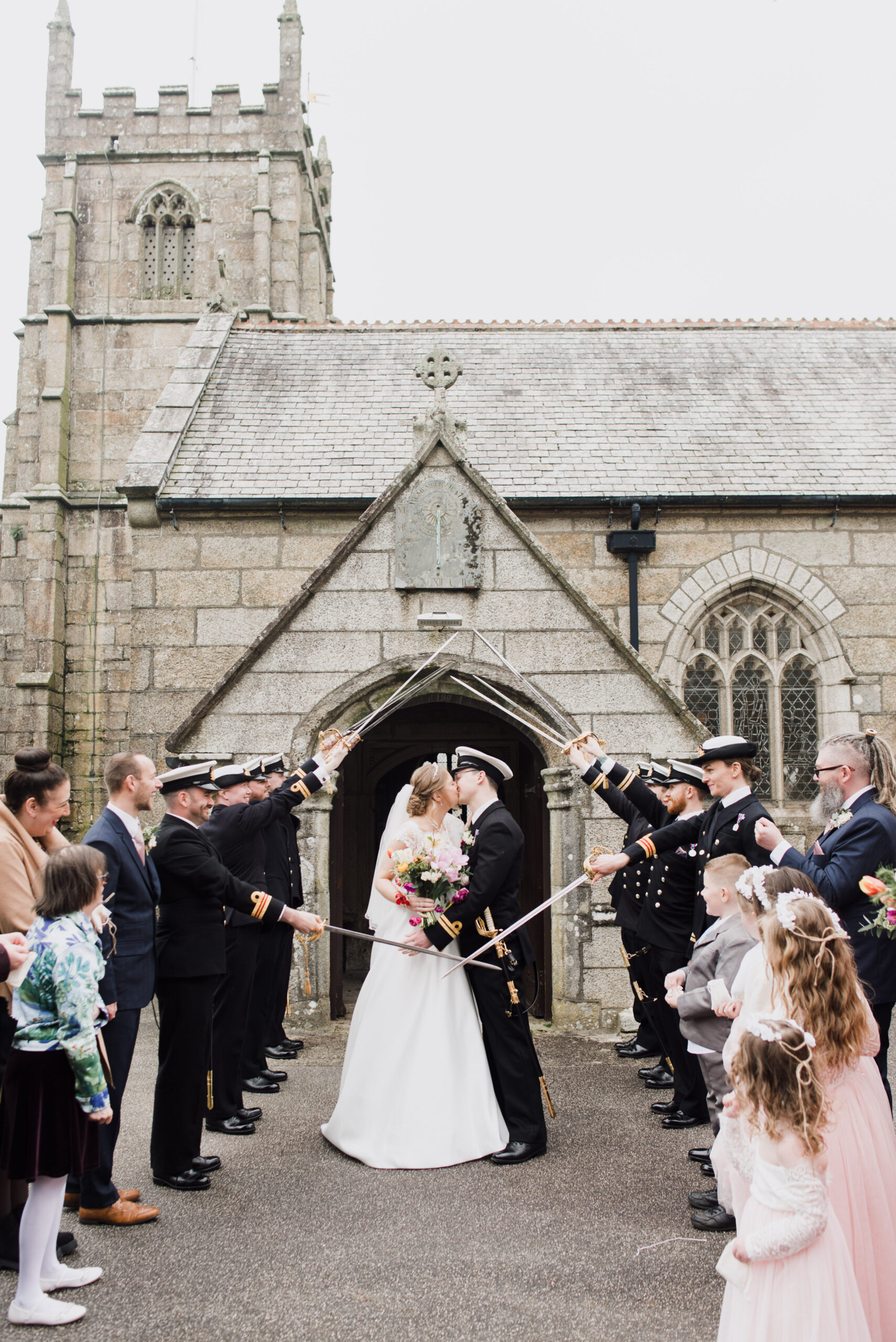 A newlywed couple standing in front of Camborne Parish Church